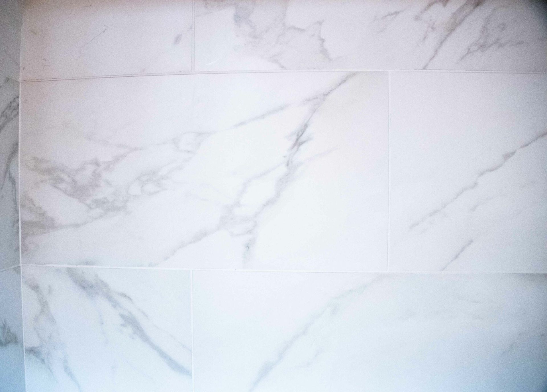 White marble tiles with gray veining on a wall or floor surface
