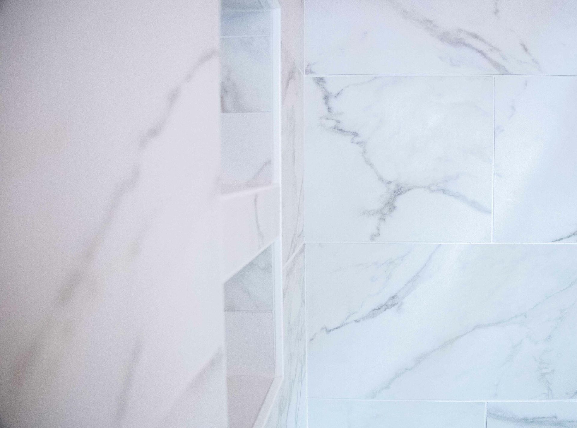 White marble-tile wall with a vertical decorative strip in the center