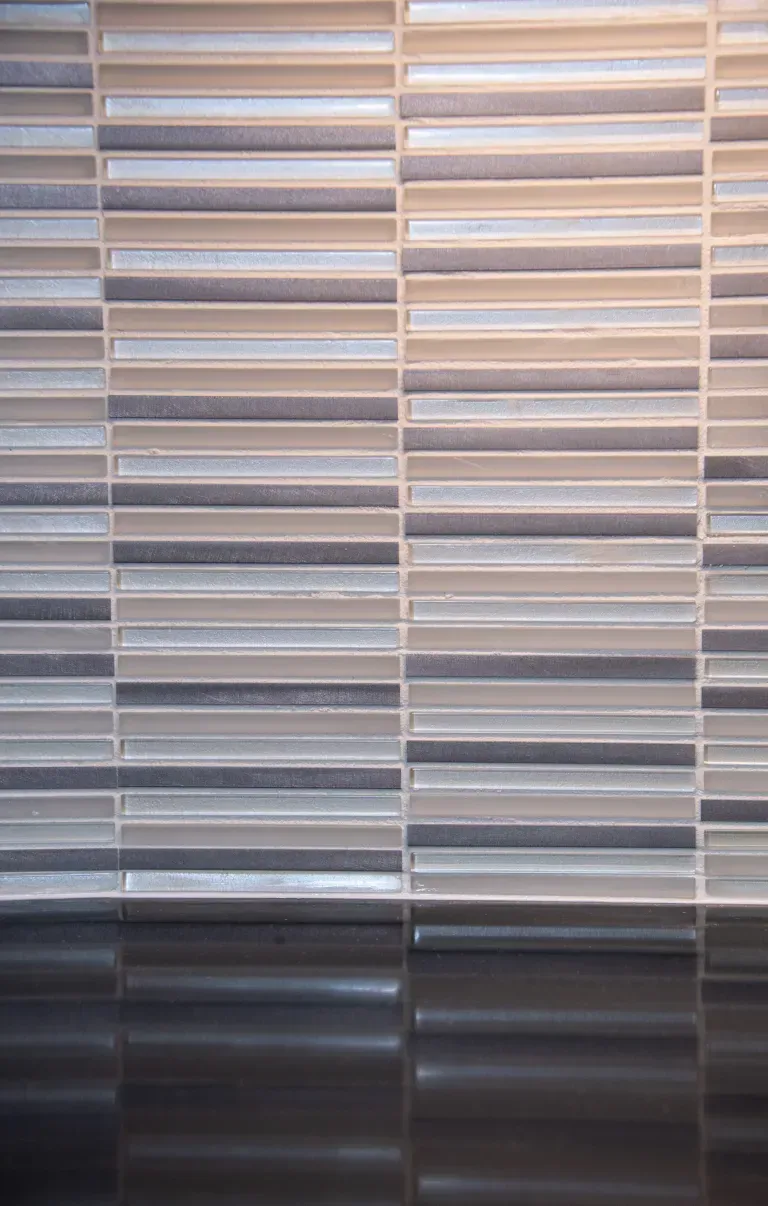 Vertical blinds with beige, gray, and dark horizontal stripes in soft light