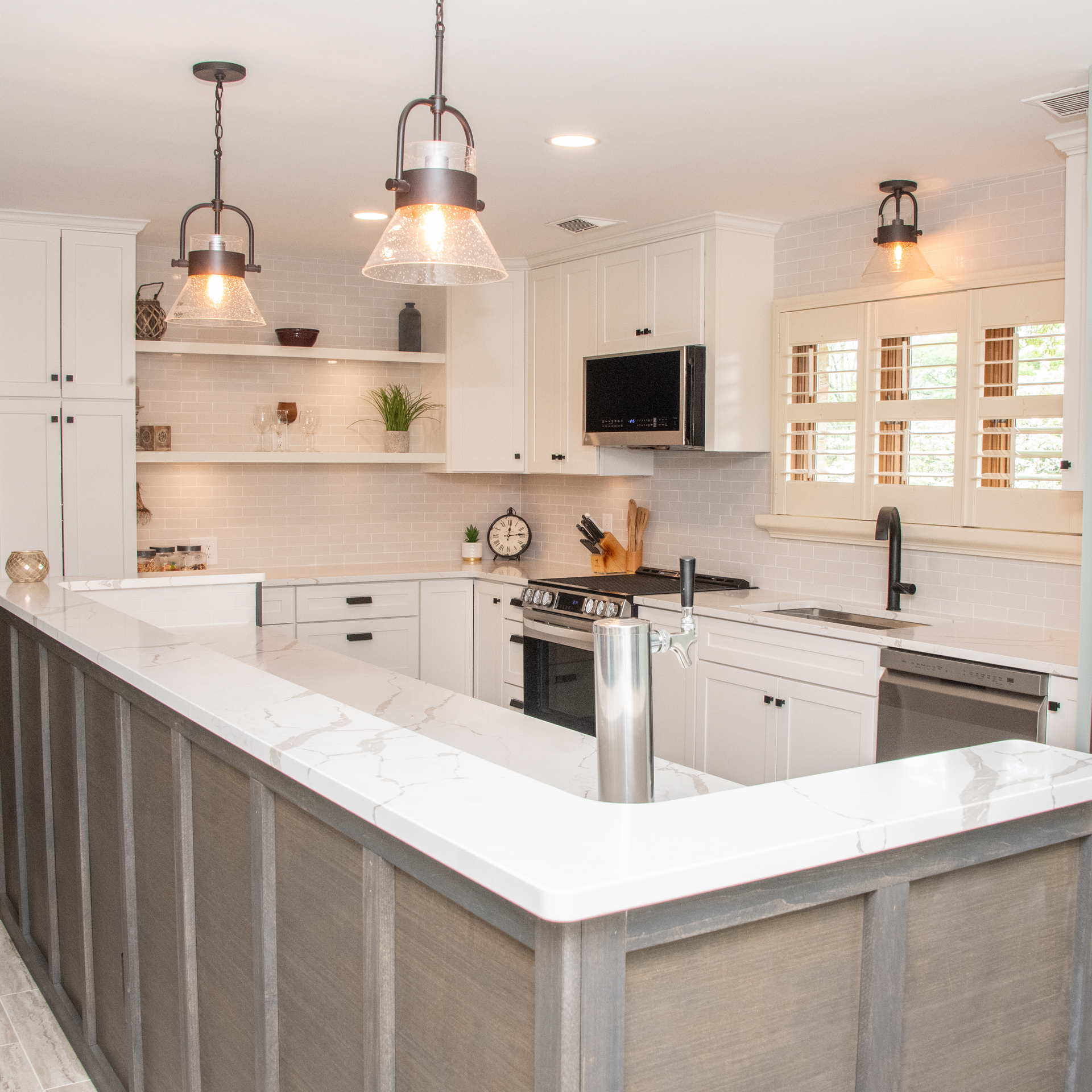 Bright white modern kitchen with island, pendant lights, and stainless steel appliances