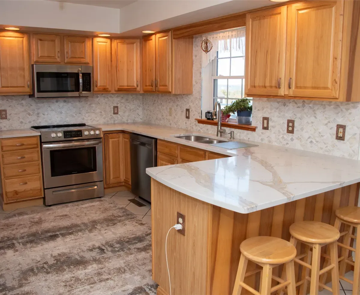 Bright kitchen with wood cabinets, stainless appliances, and a white island with stools