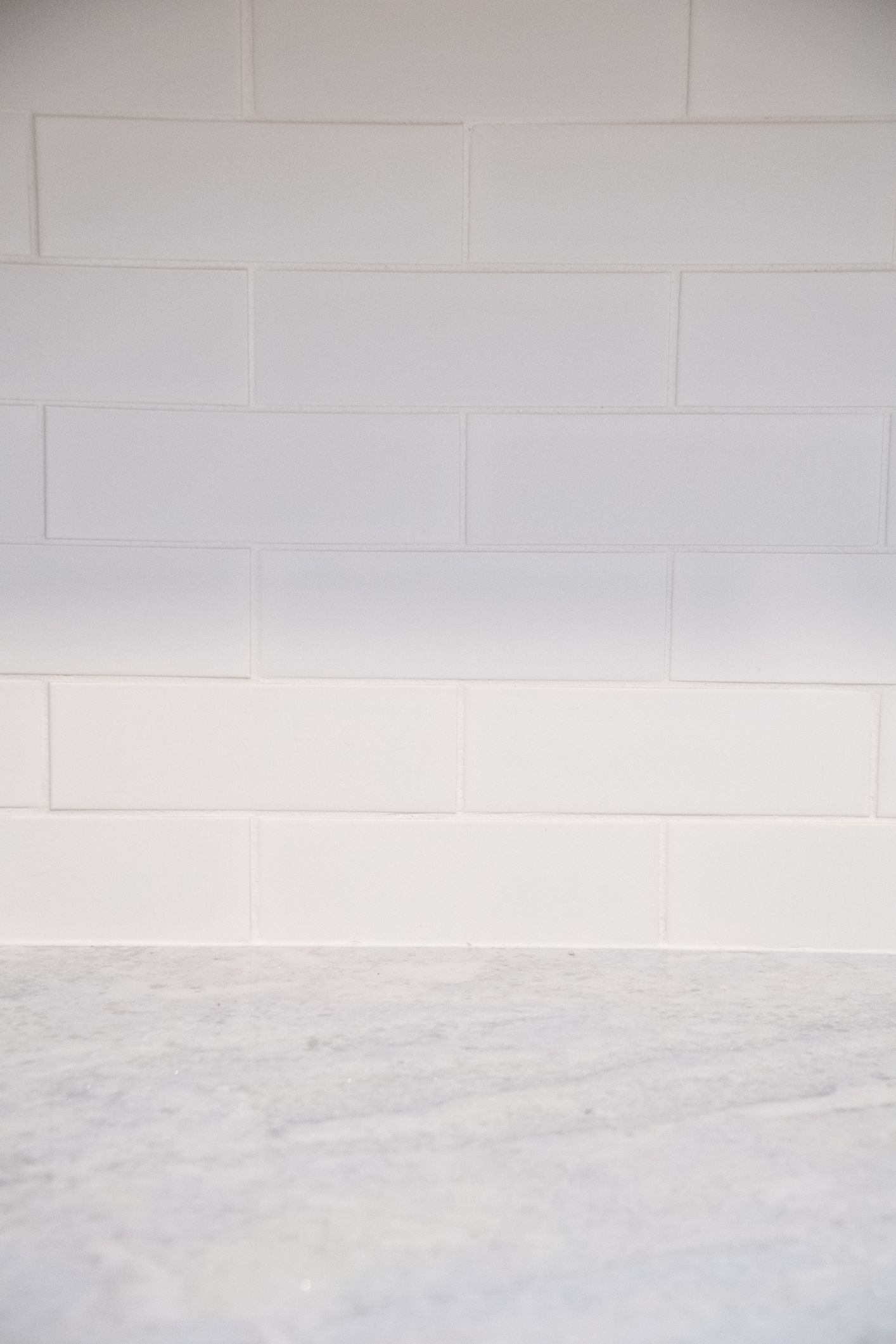 White painted brick wall above a light gray concrete floor.