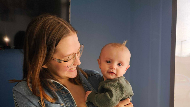 Woman and child laughing on a beige couch in a bright living room
