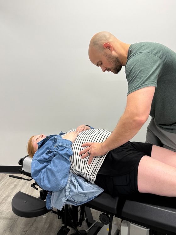 Therapist assisting a patient on a treatment table during a physical therapy session