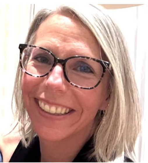 Smiling woman with blonde hair and black glasses in a close-up portrait