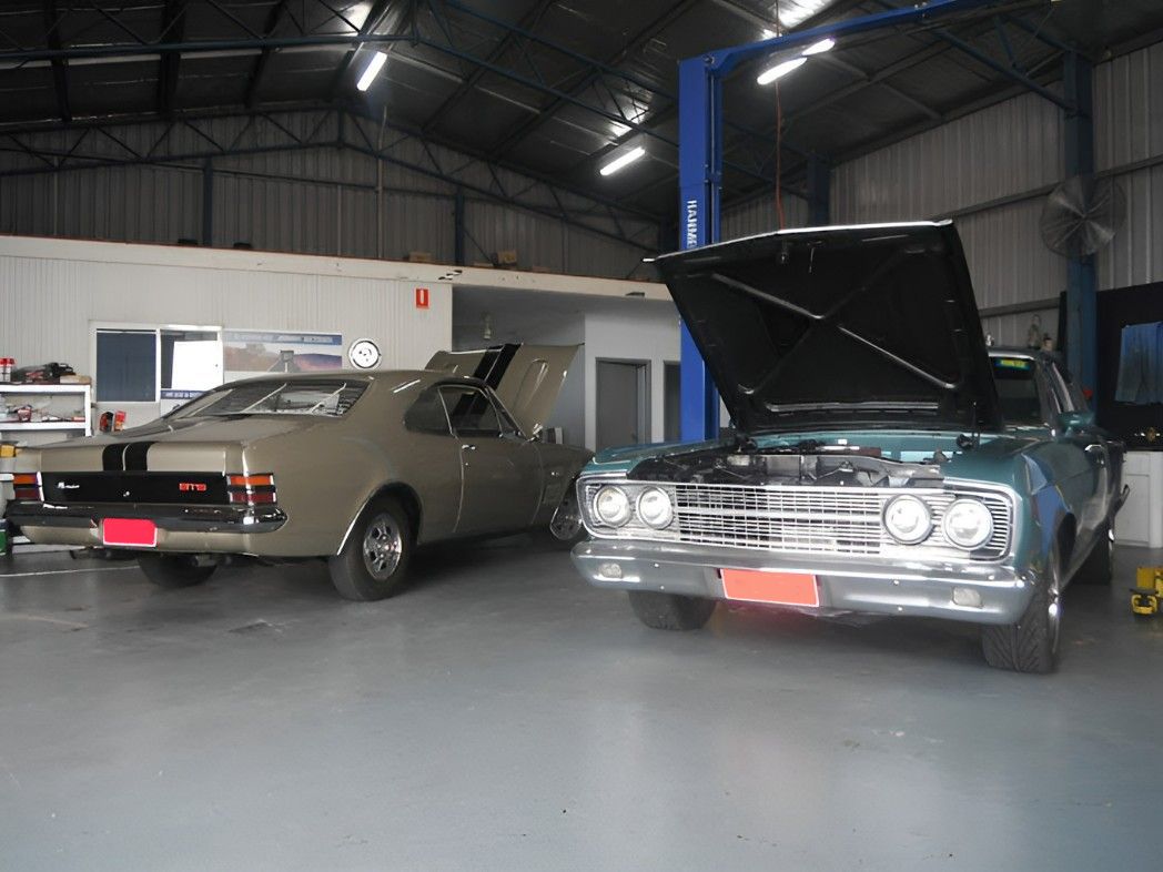 Two Cars Are Parked in a Garage With Their Hoods Open — JJE Automotive In Yarrawonga, NT
