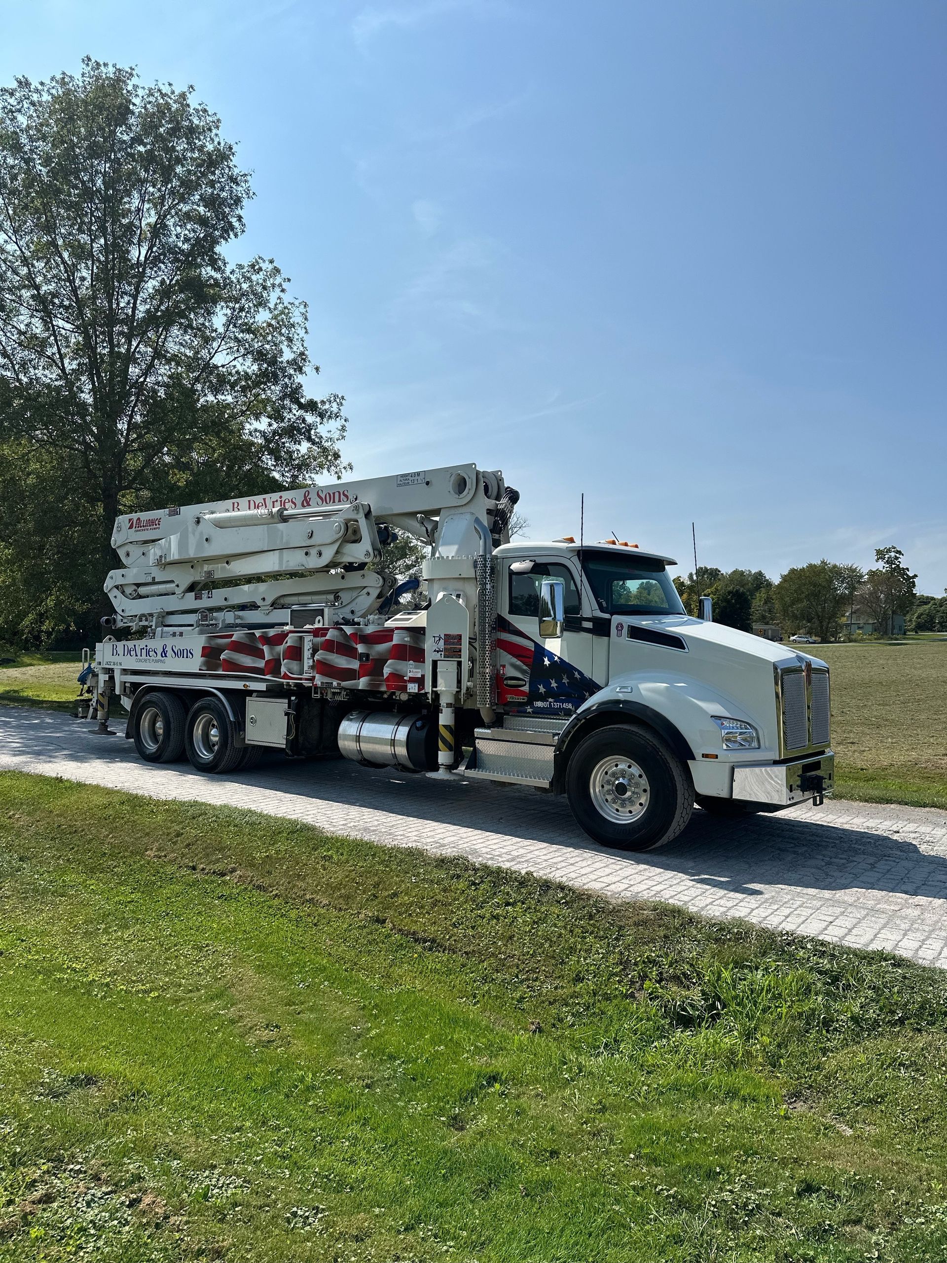 A concrete pump truck is pumping concrete in a dirt field.
