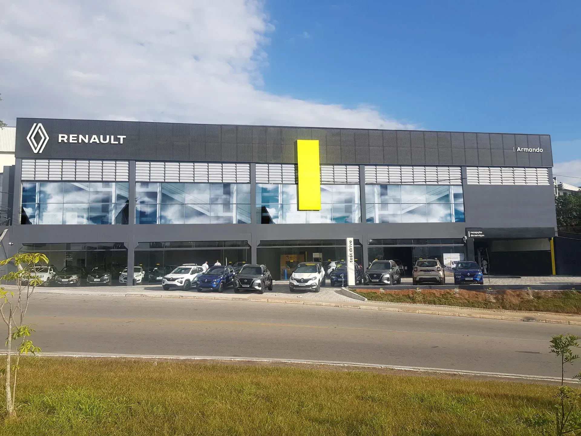 Uma concessionária de carros Renault com carros estacionados em frente a ela.