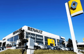 Uma concessionária de carros Renault com carros estacionados em frente a ela