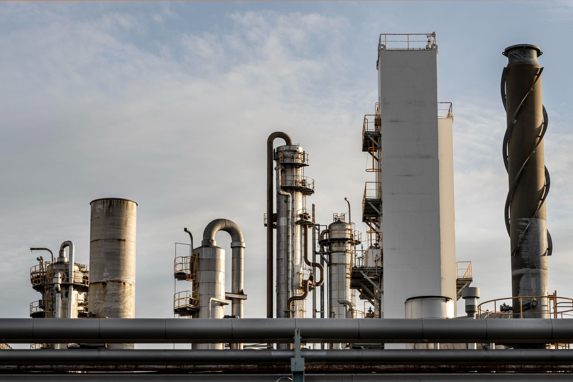 A large industrial plant with a lot of pipes and chimneys.