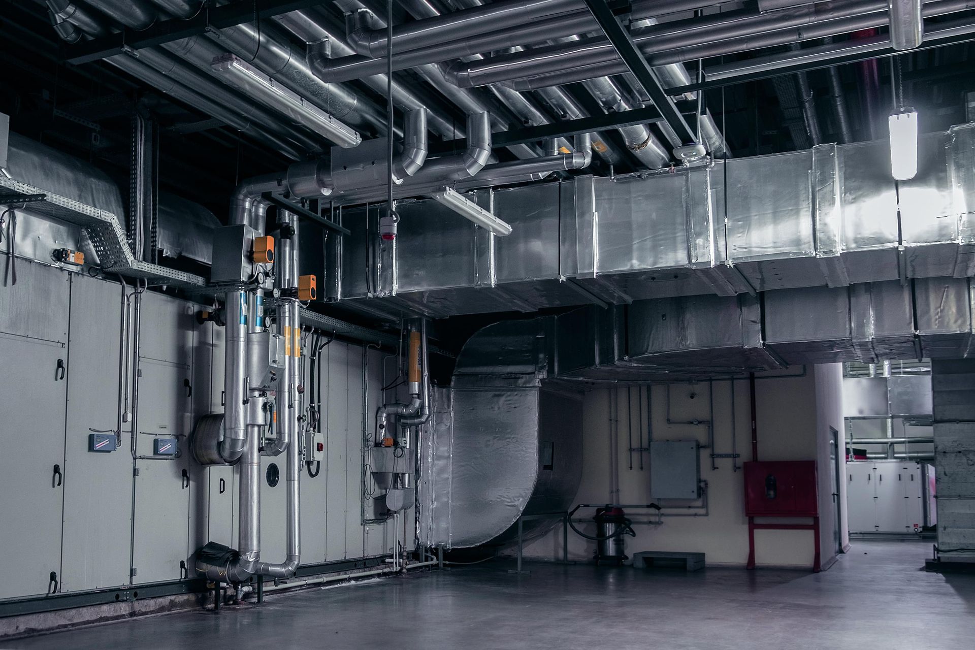 A large room with a lot of pipes hanging from the ceiling.