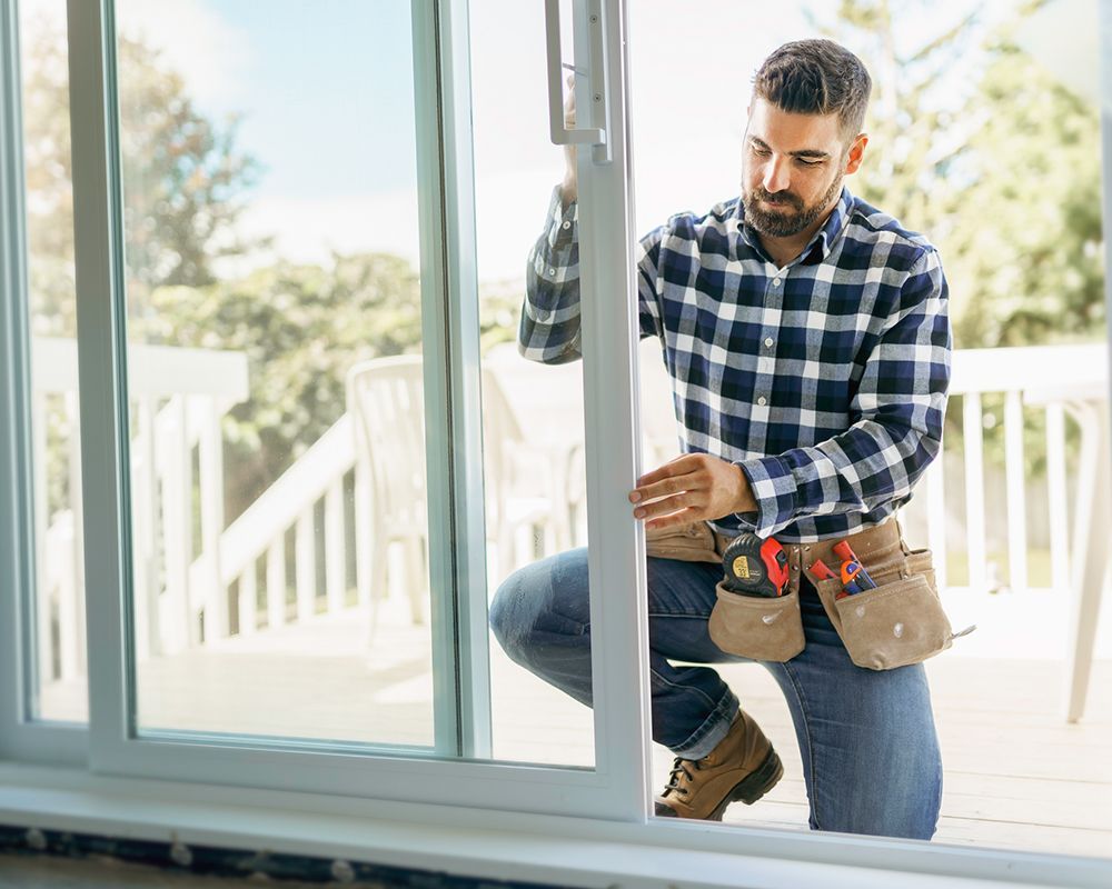 Handyman installing a bay window in a home under construction, showcasing residential window replace