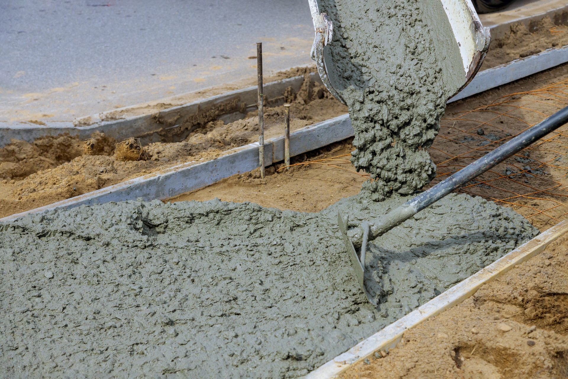 Wet concrete being poured from a chute at a construction site