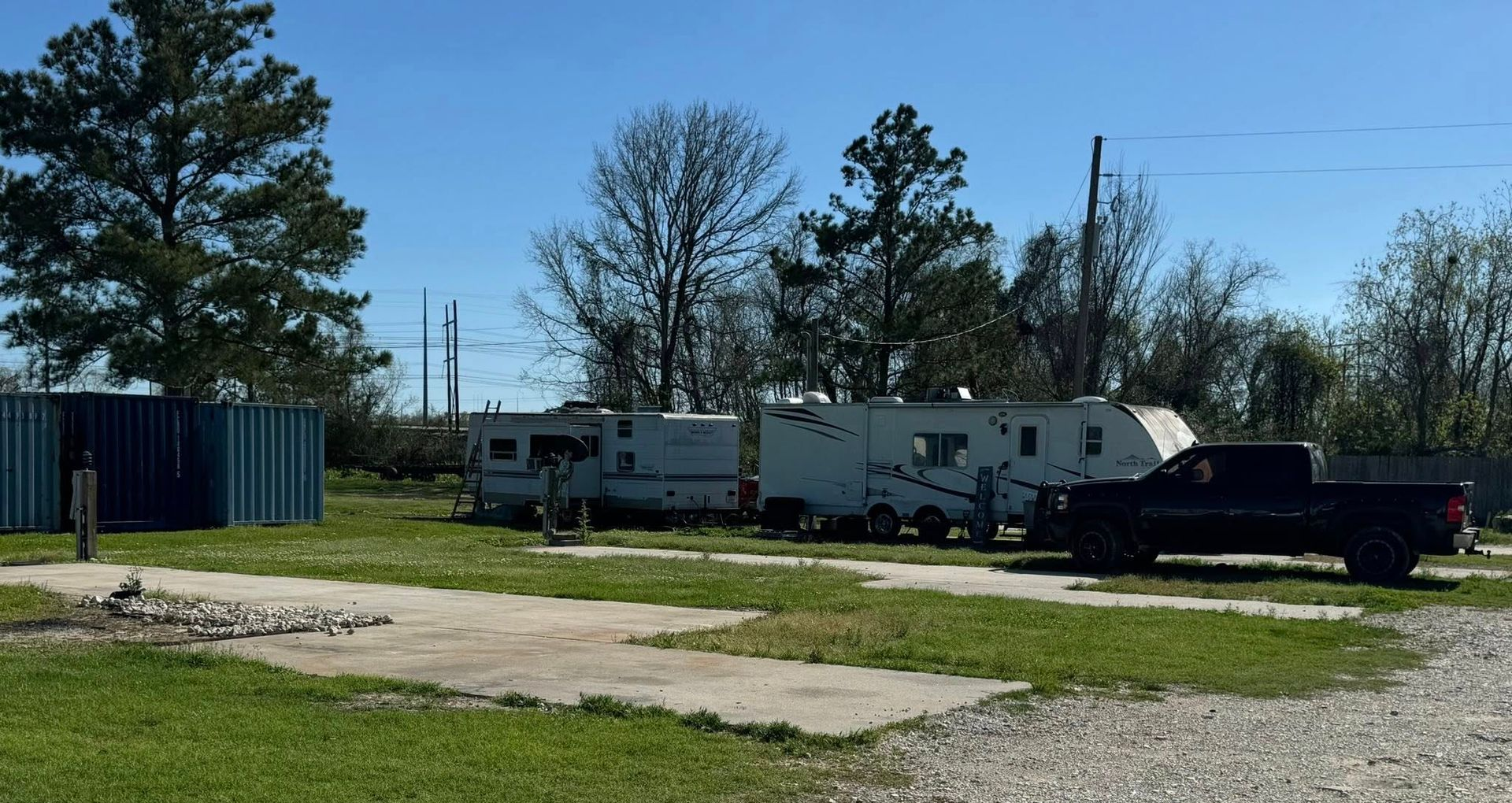 RV park with parked trailers and vehicles on a sunny day