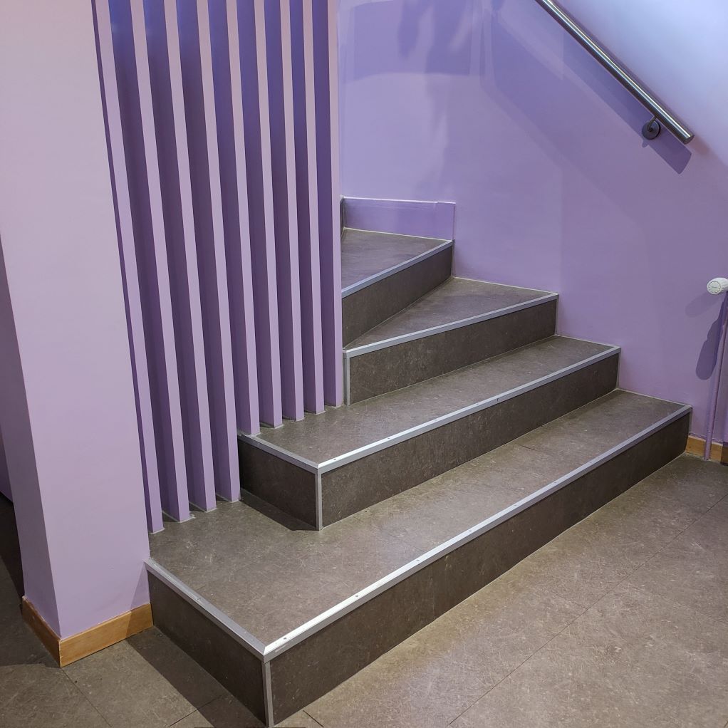 Un escalier menant à un mur violet.