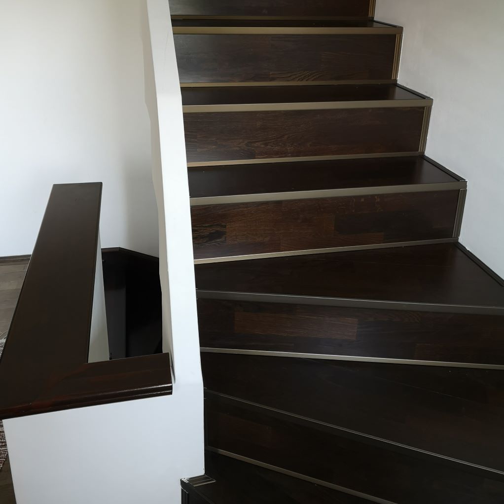 Un escalier en bois avec une rampe blanche