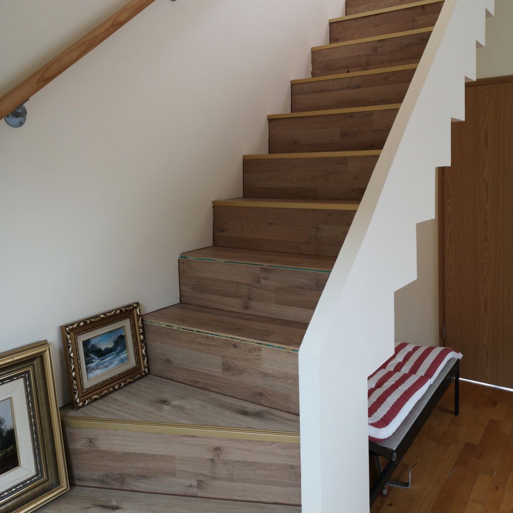 Un escalier en bois avec des tableaux sur les marches