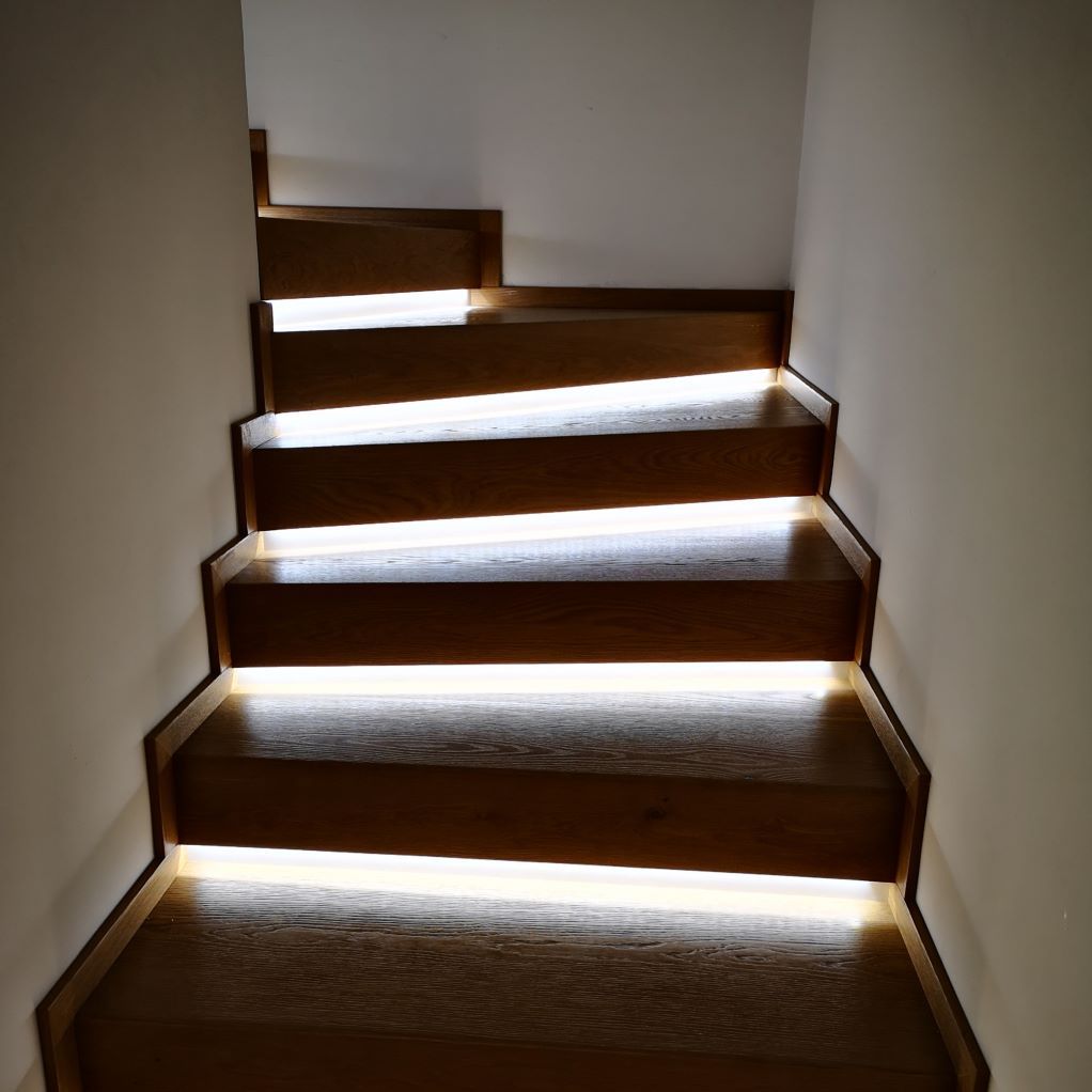 Un escalier en bois avec des lumières sur les marches