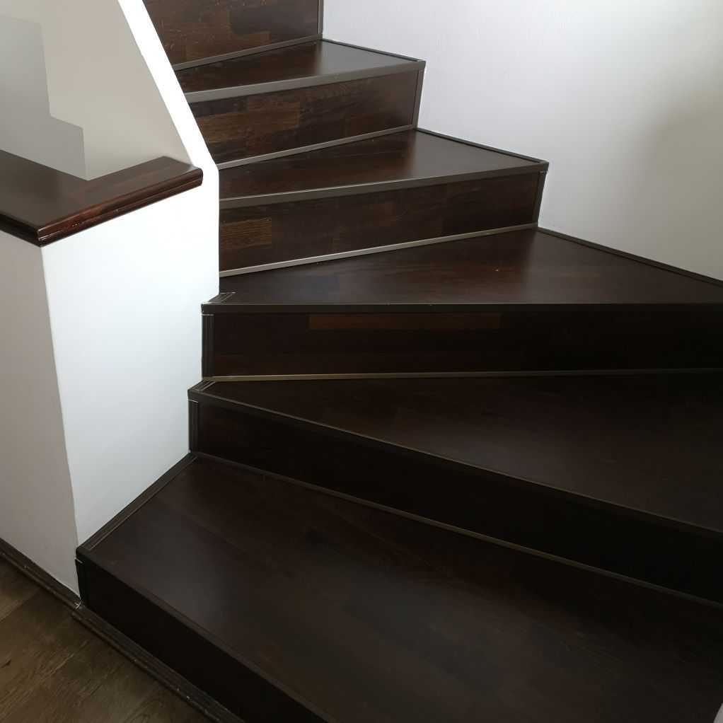 Un escalier en bois avec un mur blanc derrière