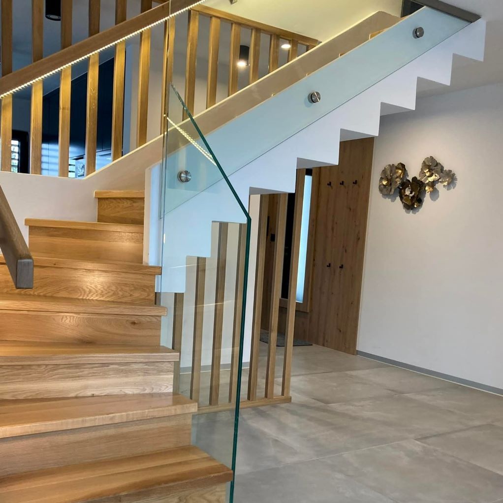 Un escalier en bois avec une rampe en verre dans une maison