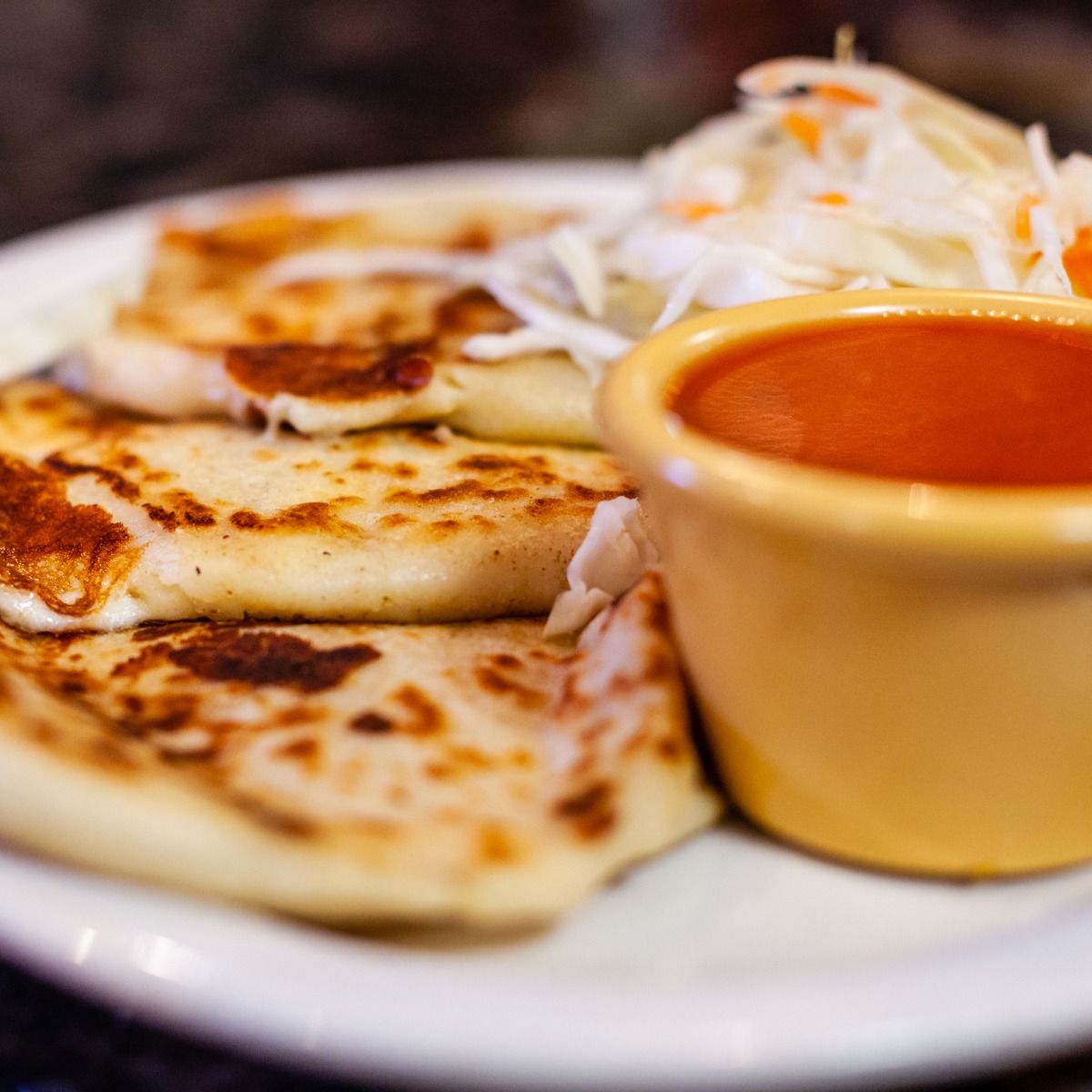 Pupusas with curtido and tomato sauce.