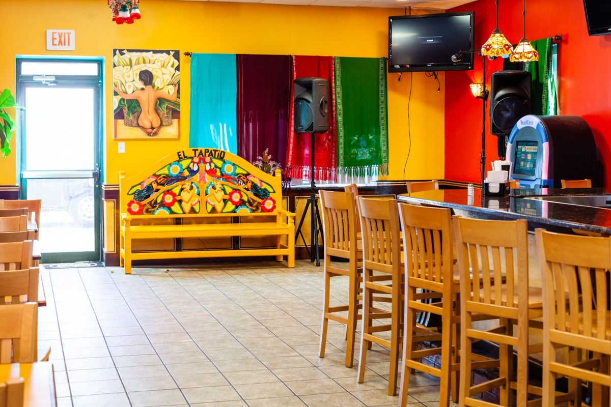 Interior of a brightly colored Mexican restaurant with bar and stage.
