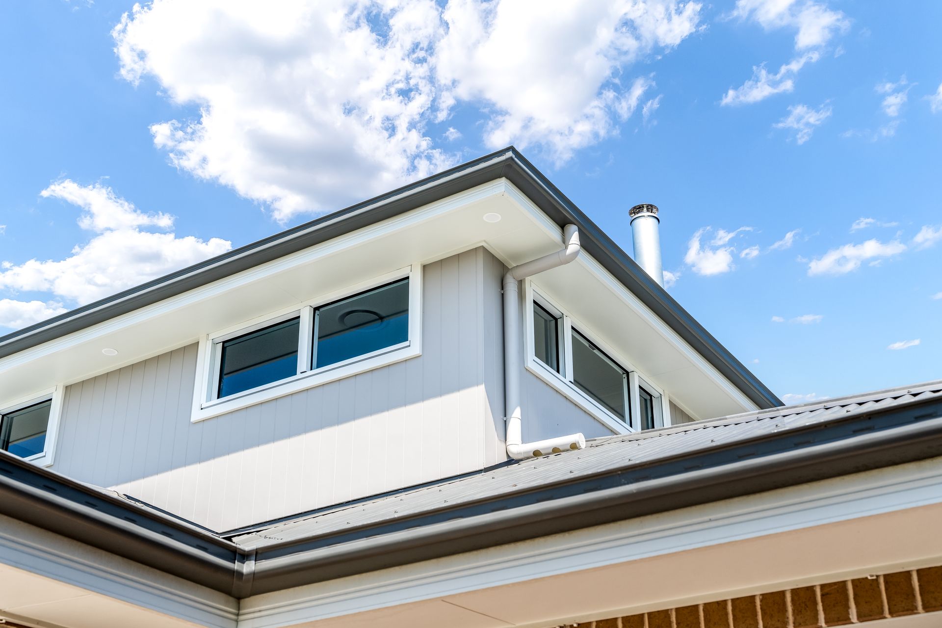 Modern White House Exterior With Upper Windows and Blue Sky — Matt Made Building in Camden, NSW