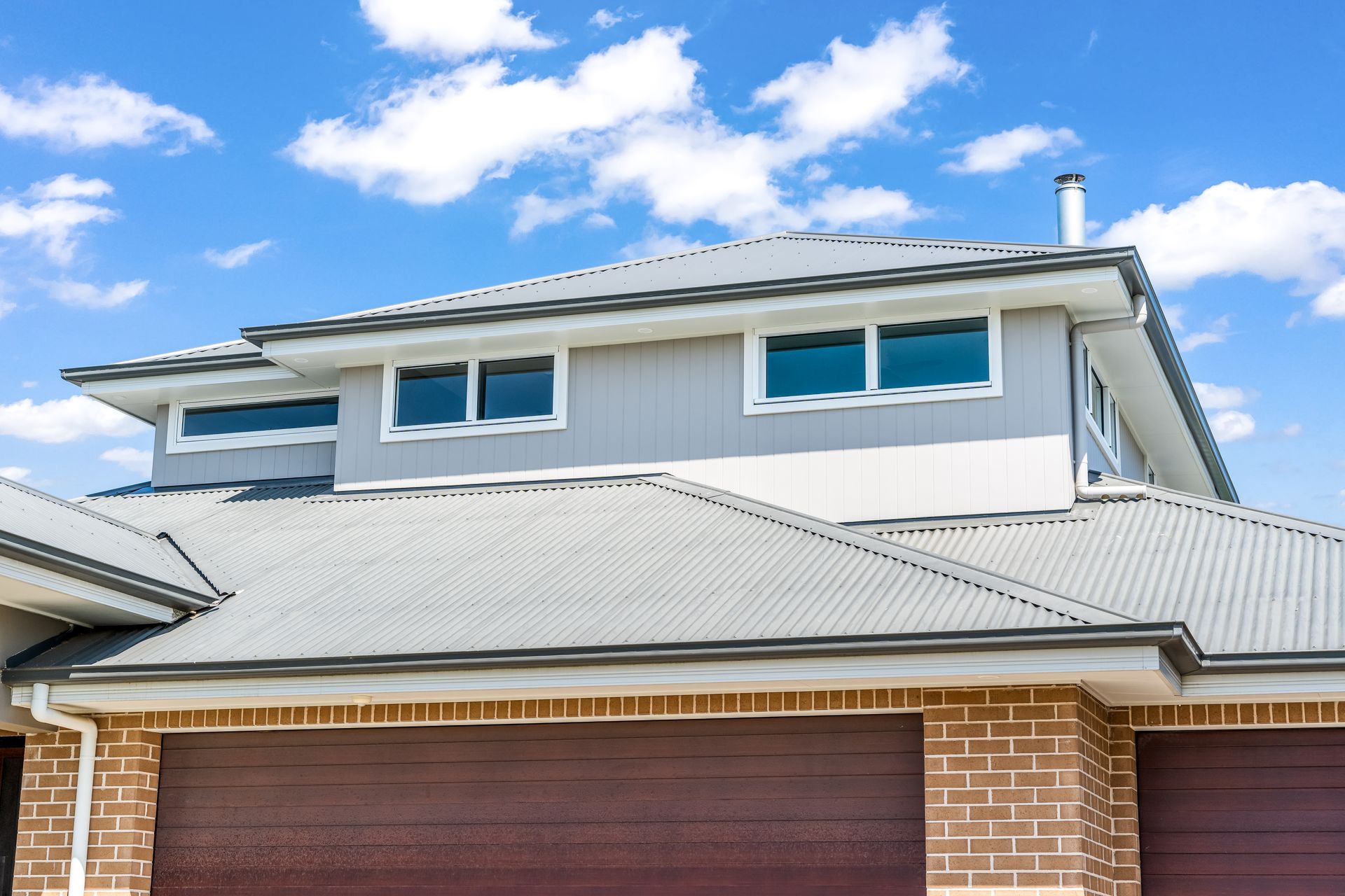 Two-story Brick House With a Gray Metal Roof and Blue-framed Windows — Matt Made Building in Camden, NSW