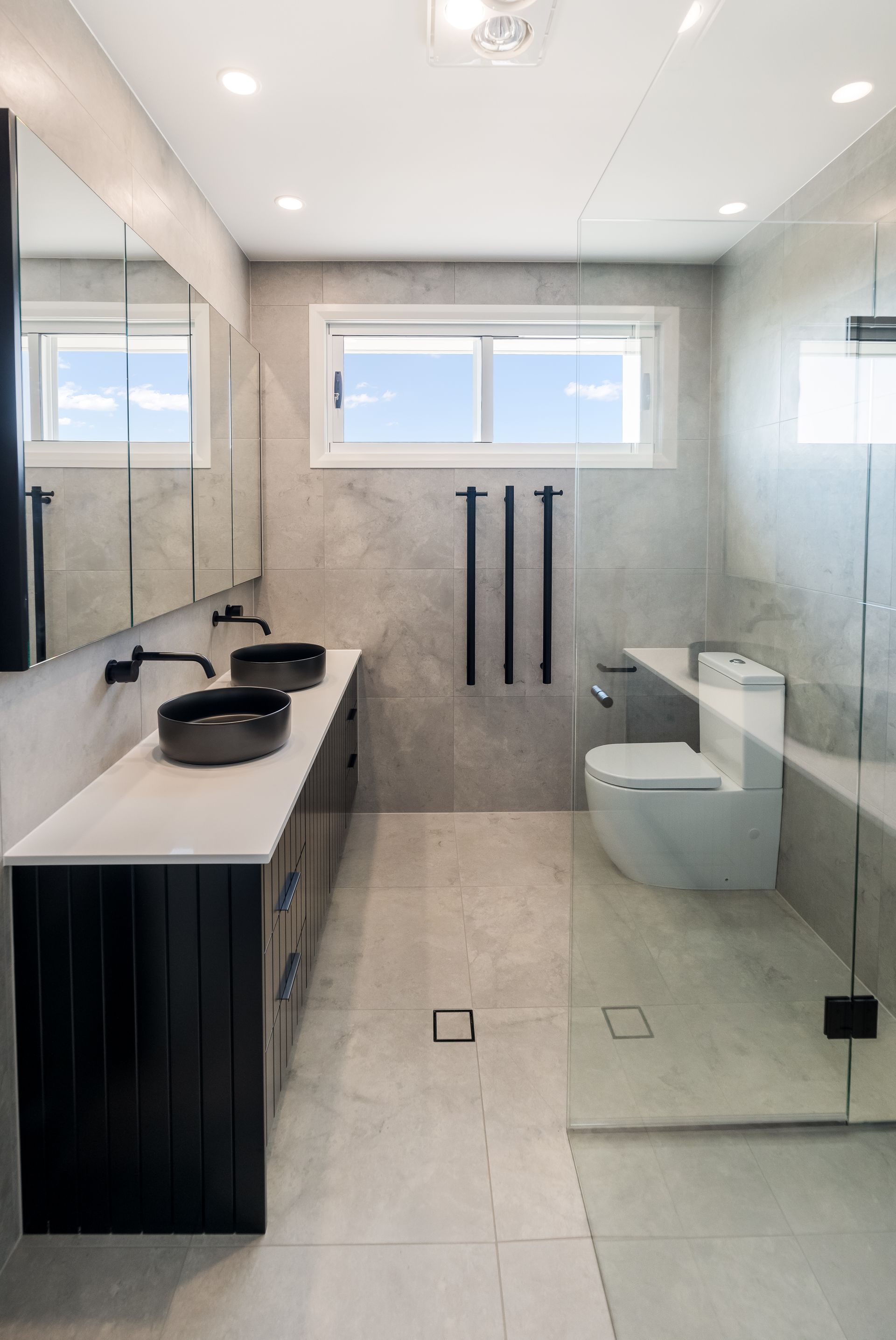 Modern Bathroom With Double Sink, Glass Shower, Toilet, and Large Window — Matt Made Building in Camden, NSW