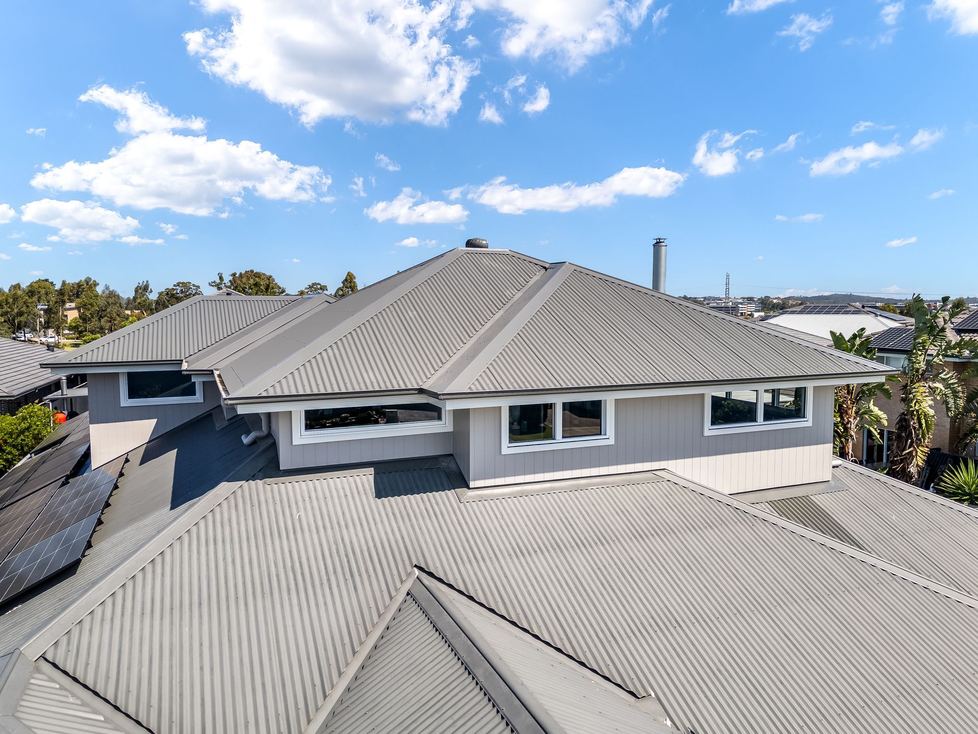 Aerial View of a Gray-roofed House Under a Blue Sky With Scattered Clouds — Matt Made Building in Camden, NSW