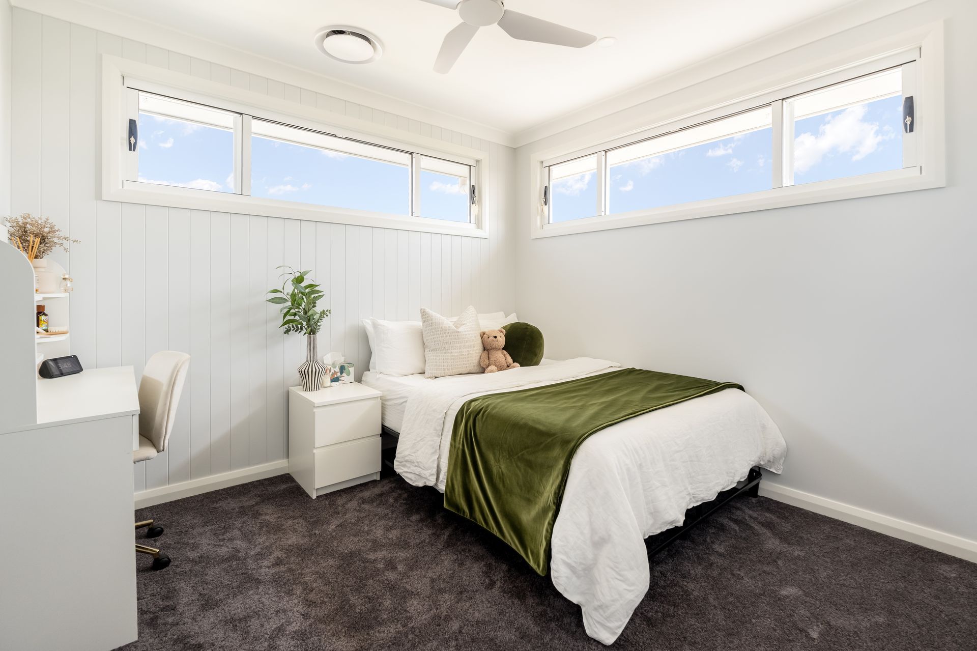 Bright White Bedroom With a Bed, Green Blanket, and Large Corner Windows — Matt Made Building in Camden, NSW