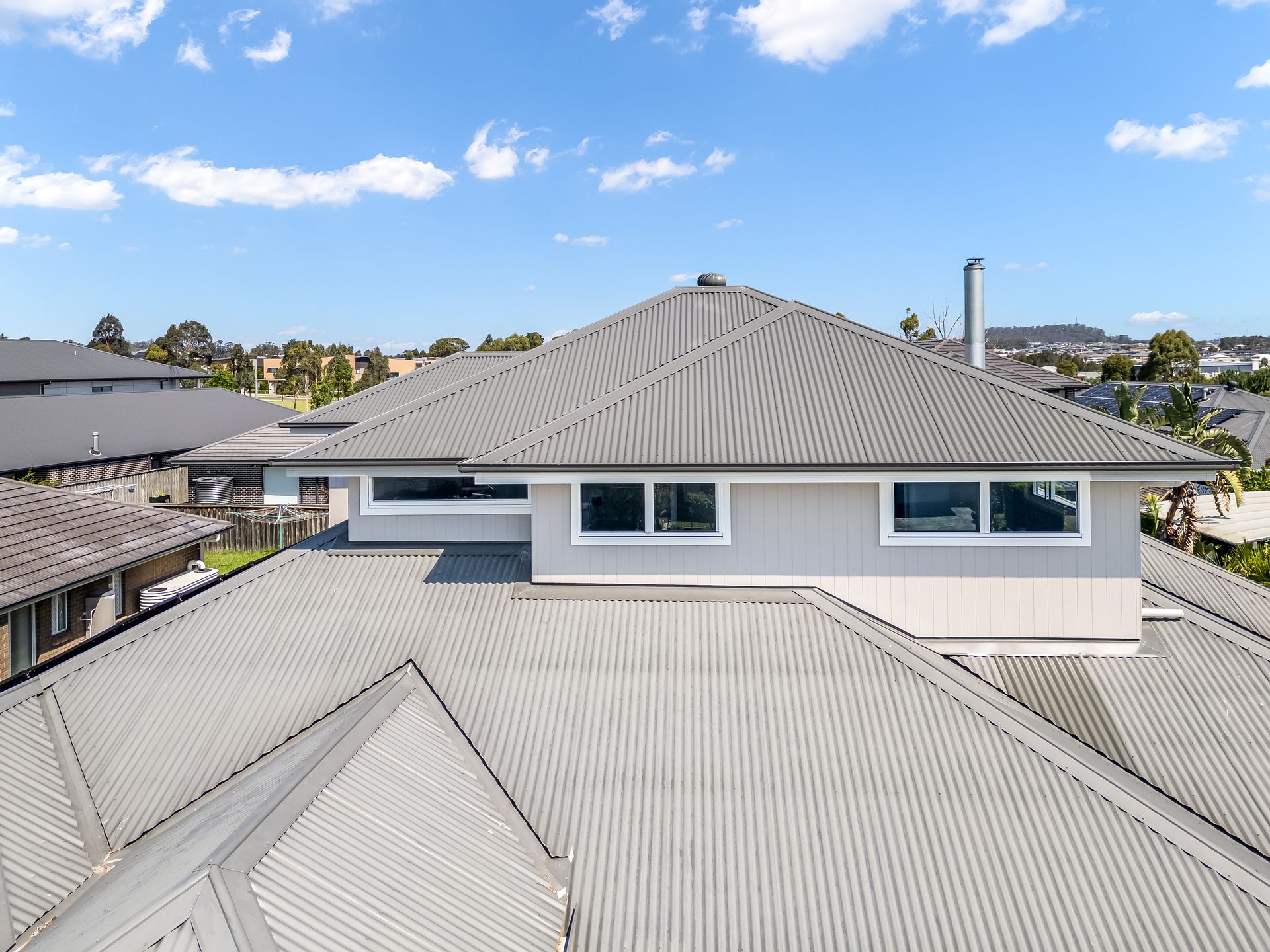 View From Rooftops of a Gray House With Corrugated Metal Roofs — Matt Made Building in Camden, NSW