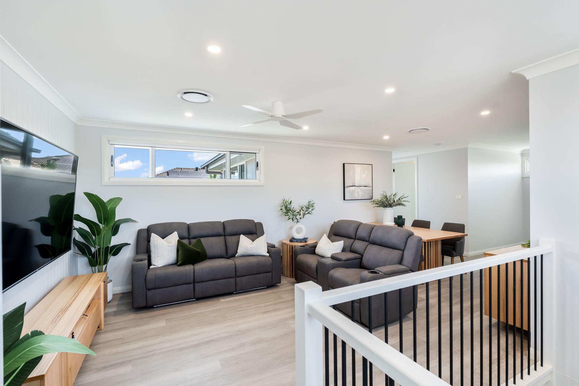 Bright Open Living Room With Gray Sofas and a Staircase Railing in the Foreground — Matt Made Building in Camden, NSW