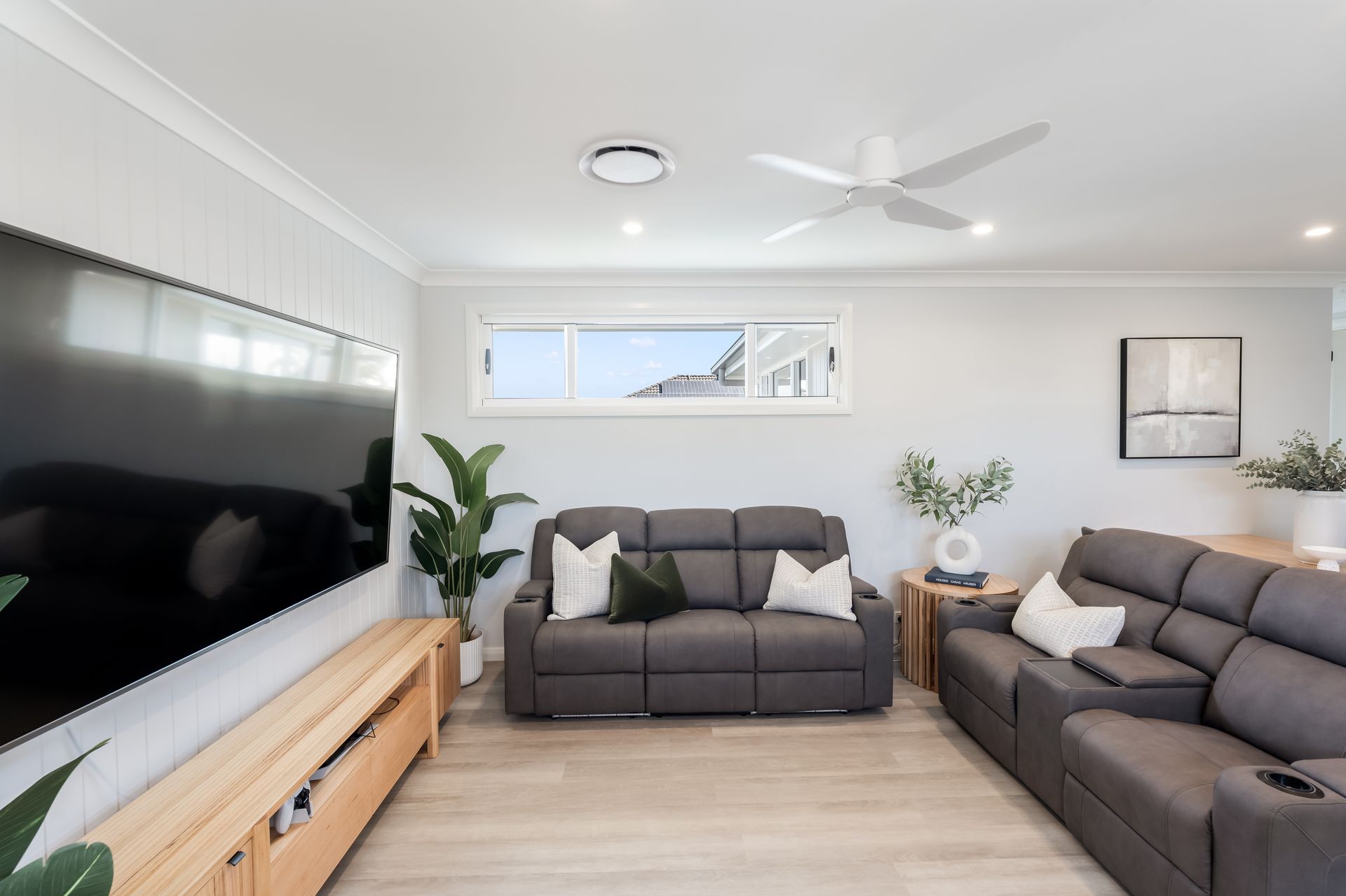 Bright Modern Living Room With Gray Sofas, Wall-mounted TV — Matt Made Building in Camden, NSW