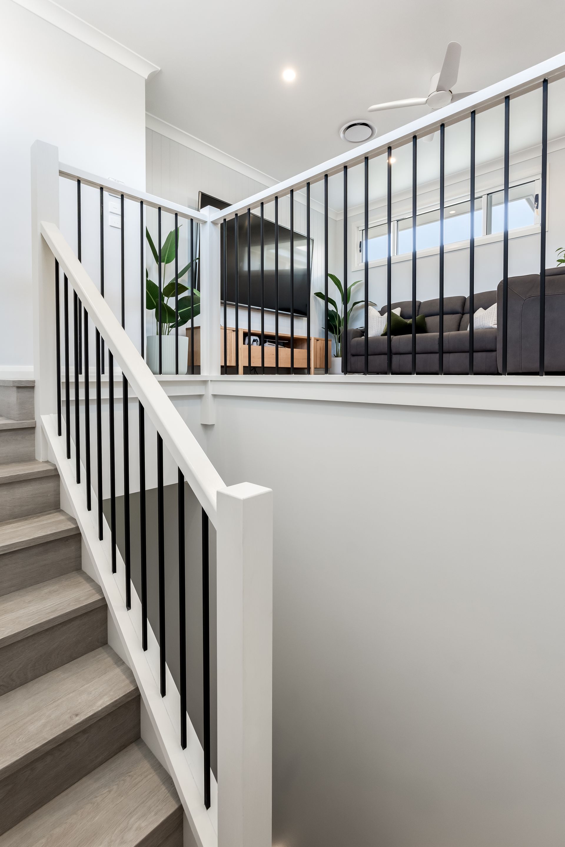 Staircase Leading to a Loft-style Living Area With Black Railing and Couch — Matt Made Building in Camden, NSW