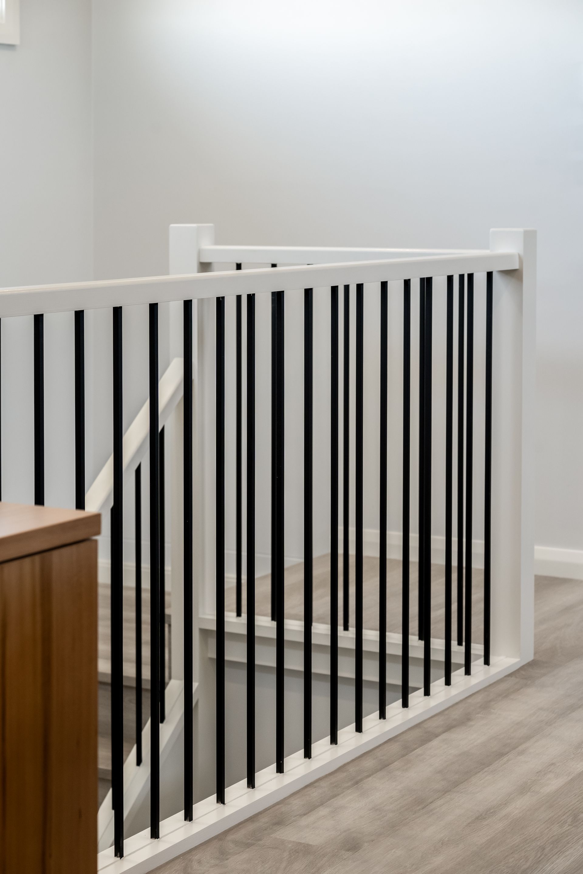 White Staircase Railing With Black Vertical Bars Beside a Carpeted Stairway — Matt Made Building in Camden, NSW