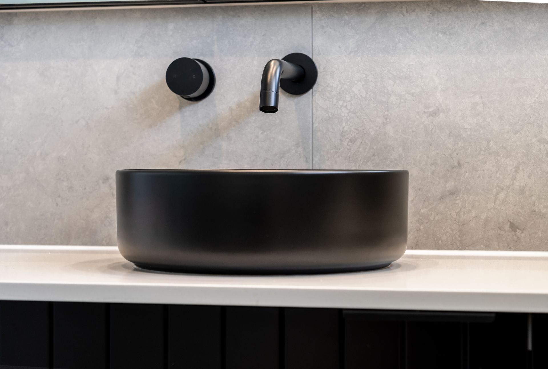 Black Vessel Sink With Wall-mounted Faucet on a Light Stone Countertop — Matt Made Building in Camden, NSW