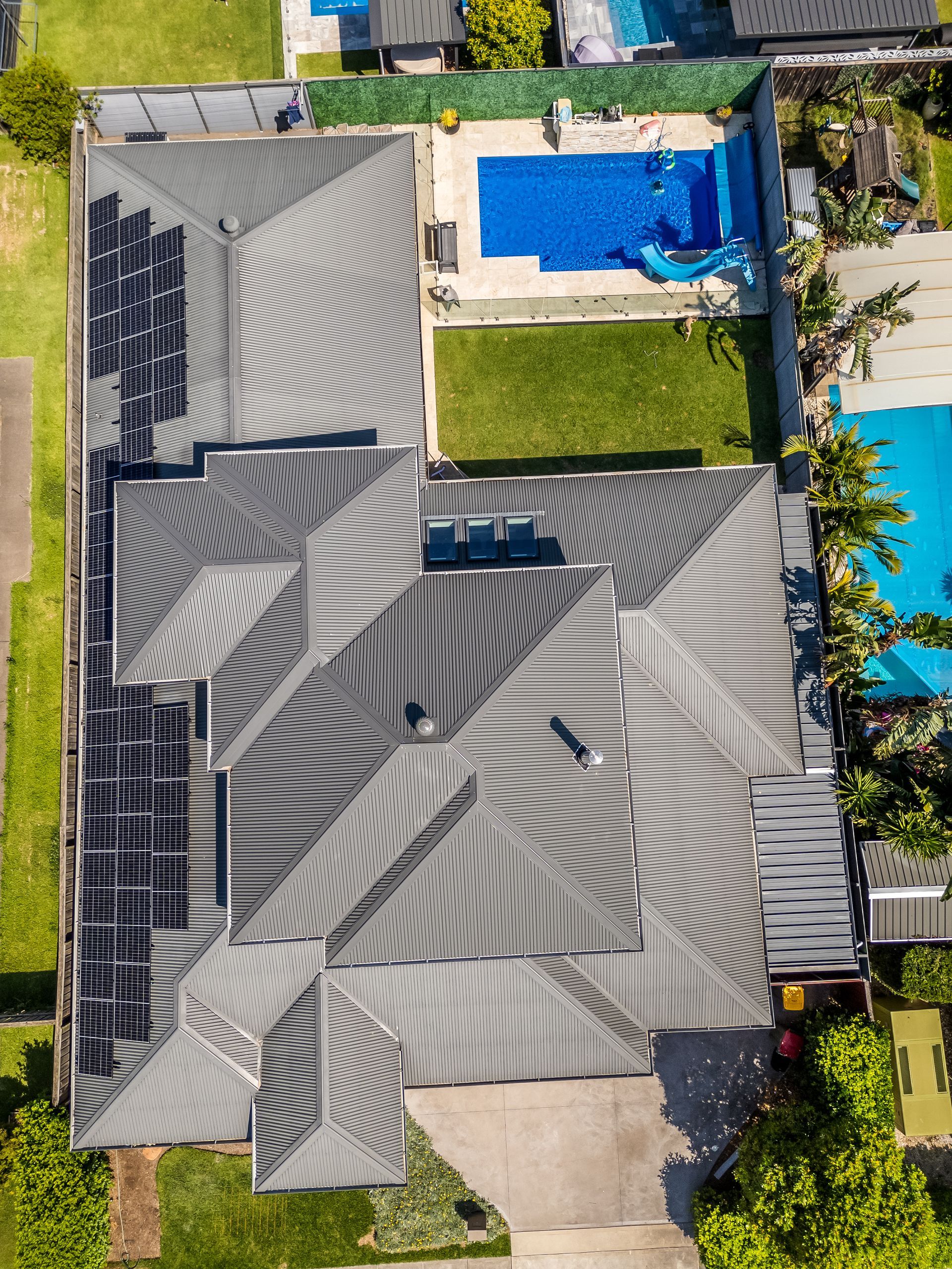 Aerial View of a House With Gray Roof, Solar Panels and Blue Patio Furniture — Matt Made Building in Camden, NSW