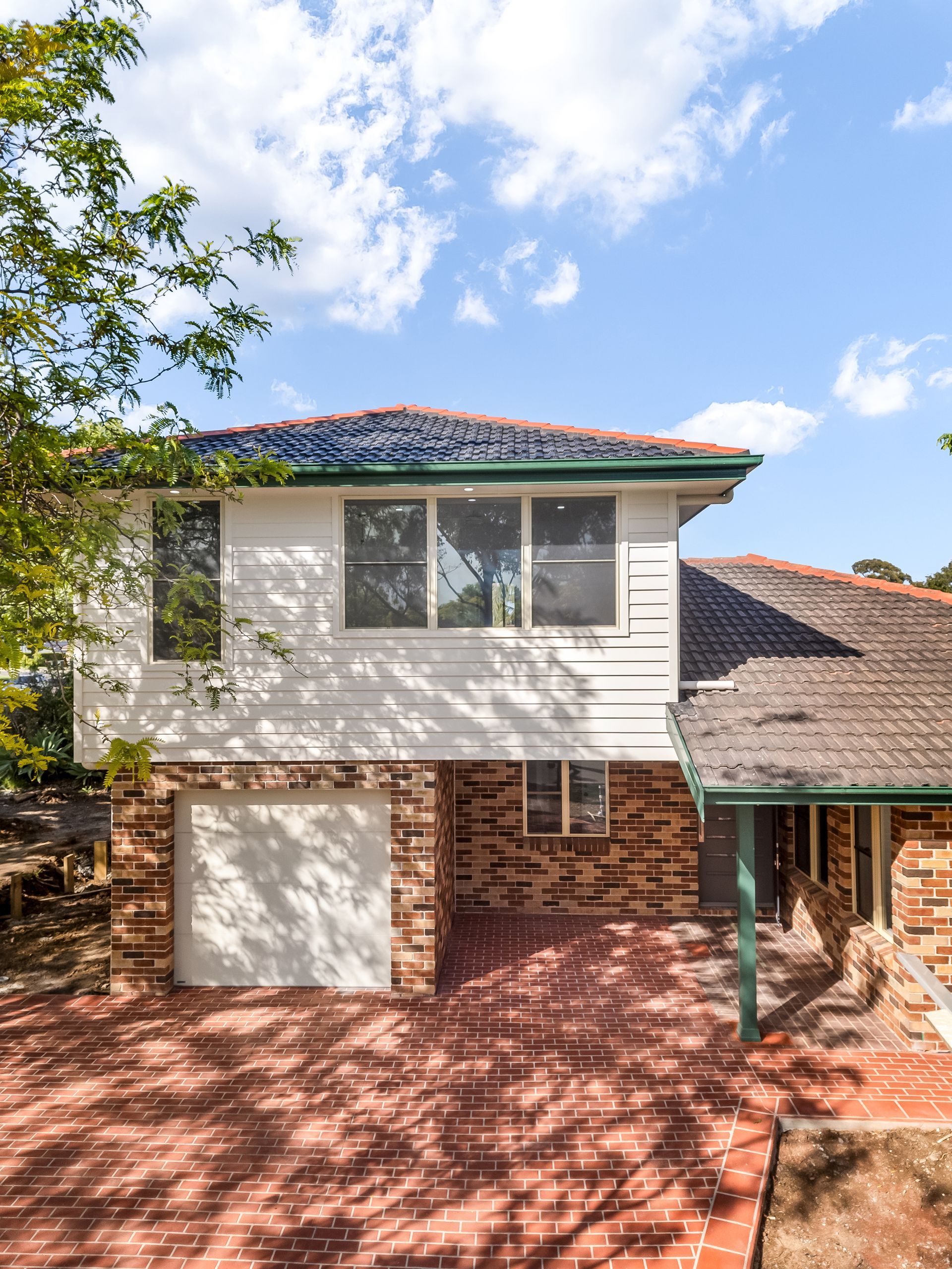 Two-story Brick and White House With Red Tile Roof Under a Blue Sky — Matt Made Building in Camden, NSW