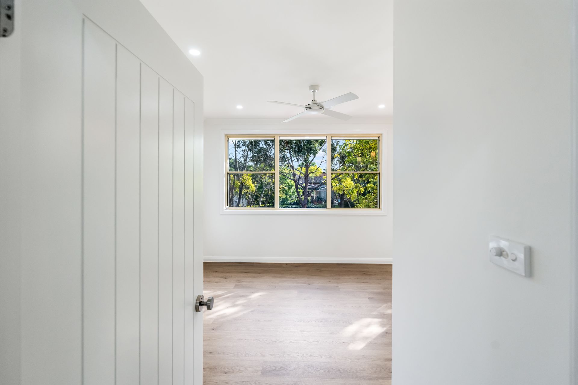 Empty White Room With Wood Floor, Large Window, and Open Door — Matt Made Building in Camden, NSW