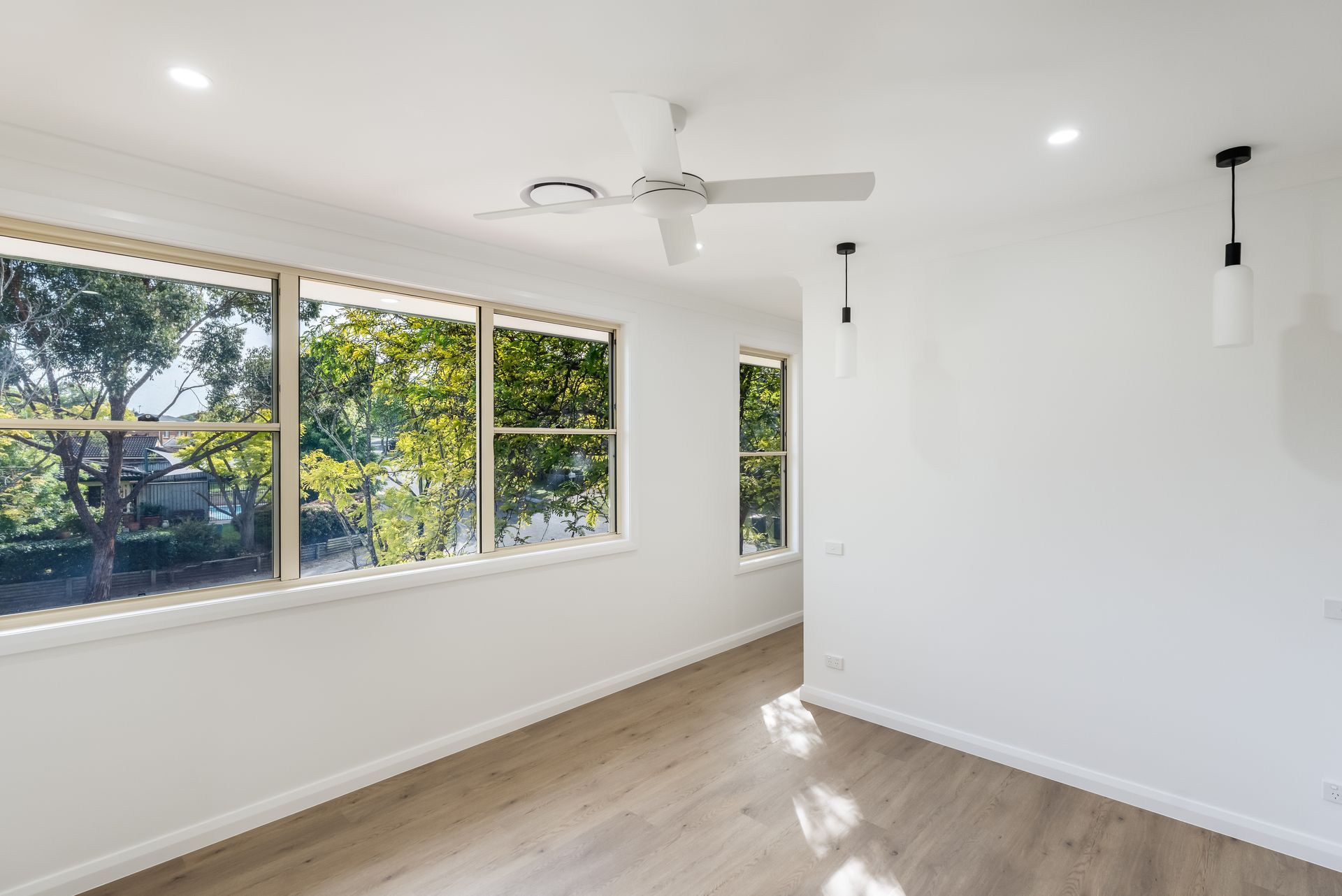 Bright Empty Room With White Walls, Large Windows and Light Wood Flooring — Matt Made Building in Camden, NSW