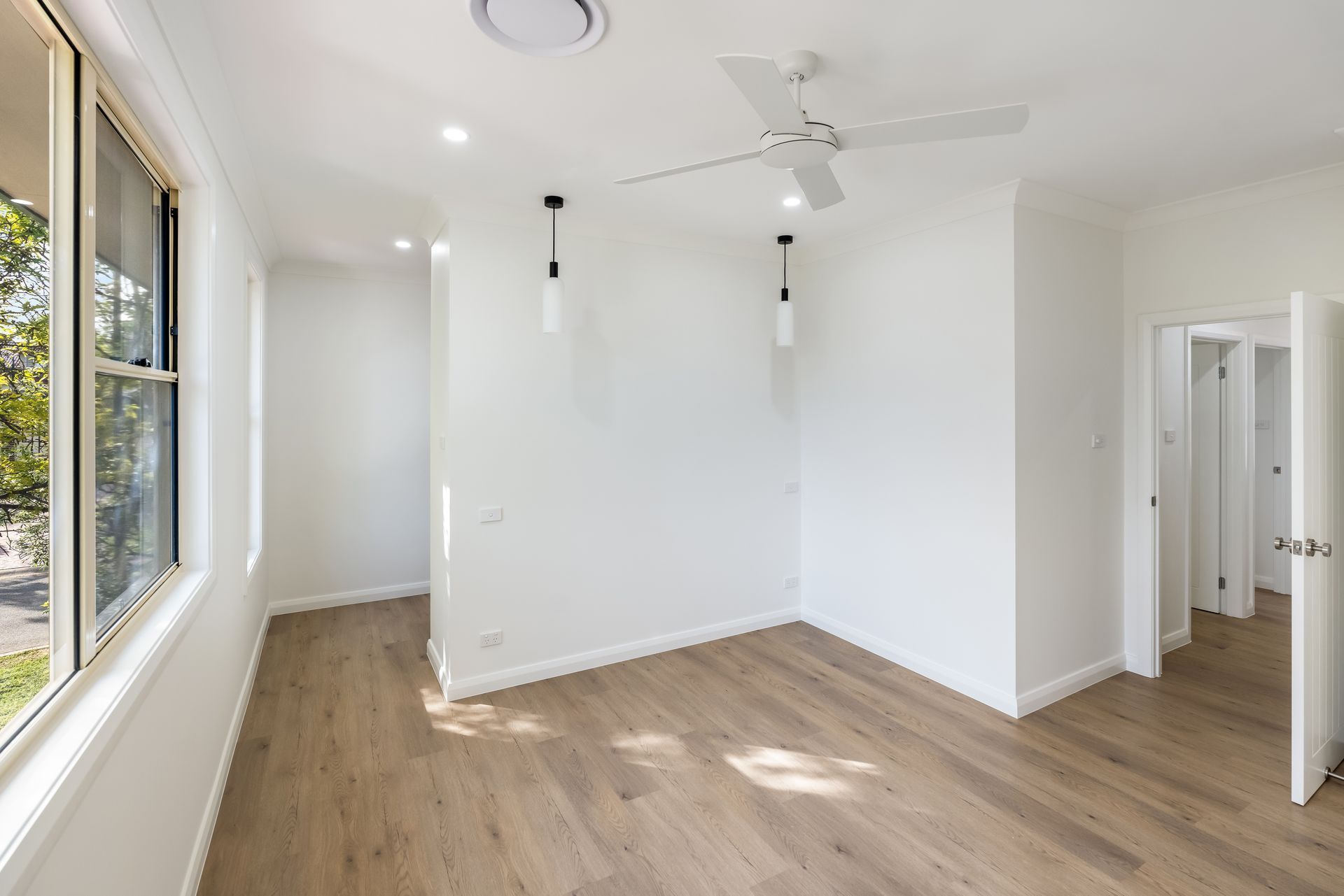 Bright Empty Room With White Walls, Wood Floors and Ceiling Fan — Matt Made Building in Camden, NSW