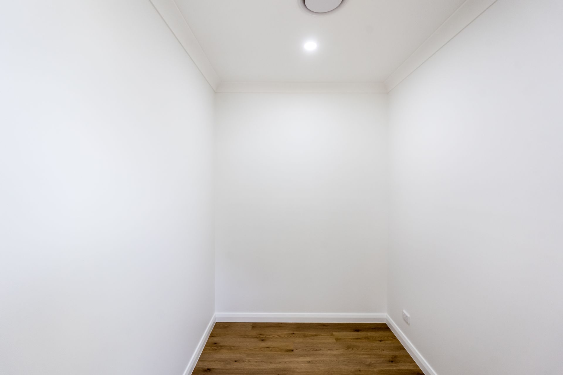 Empty White Closet With Wood Floor and a Ceiling Light — Matt Made Building in Camden, NSW