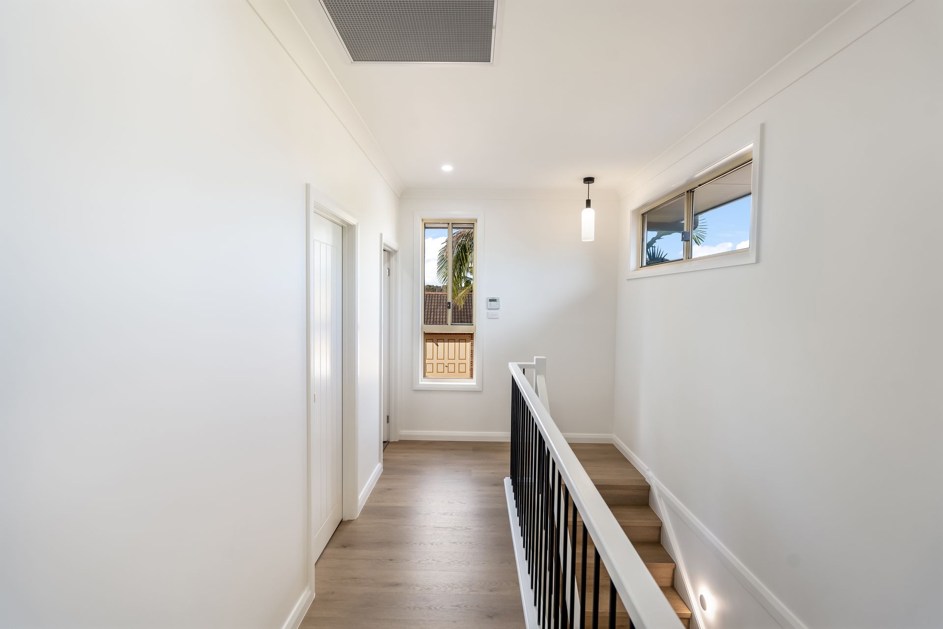 Bright Hallway With White Walls and a Small Window at the End — Matt Made Building in Camden, NSW