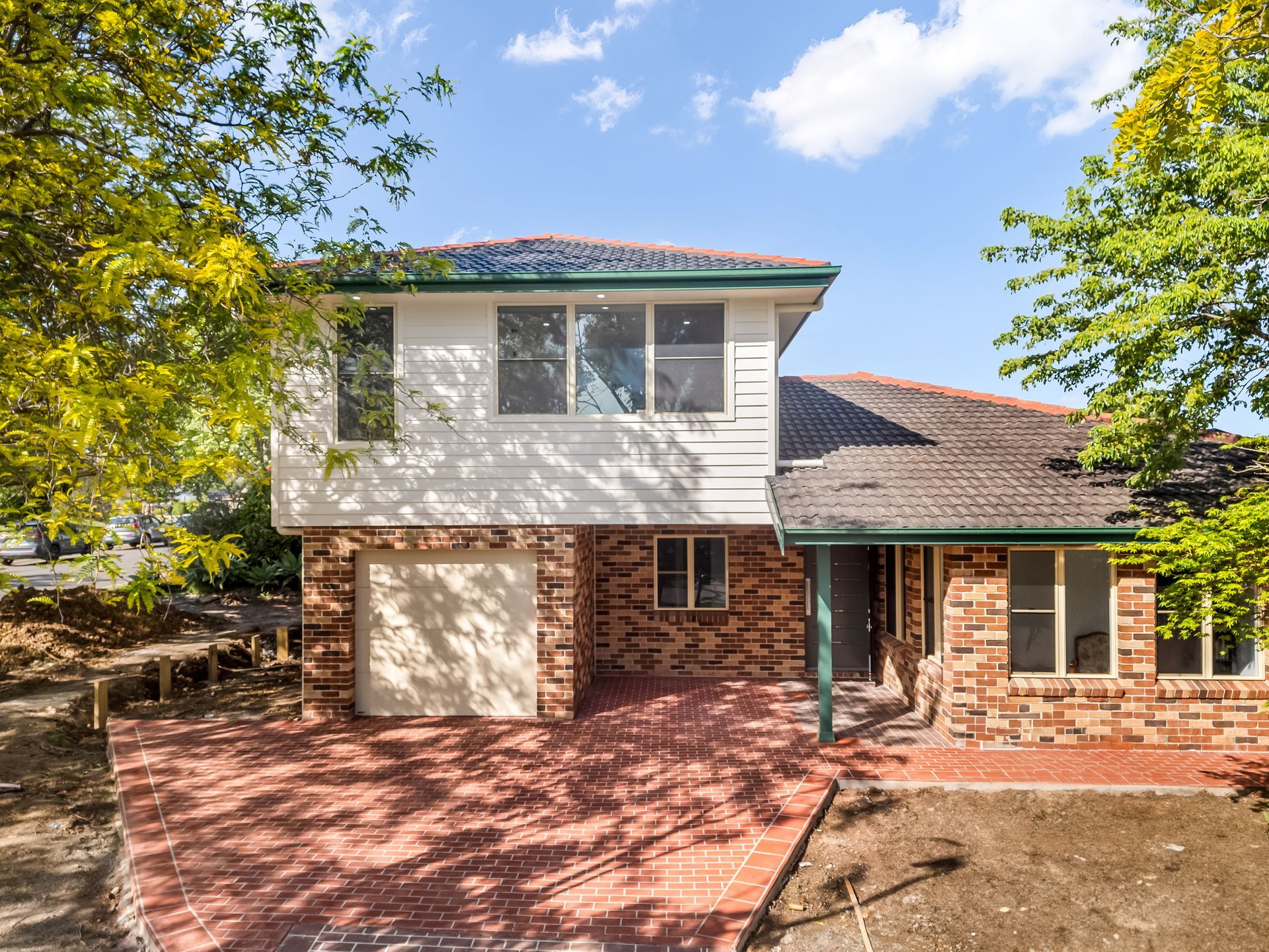 Two-story Suburban House With Brick Driveway and Trees Under a Blue Sky — Matt Made Building in Camden, NSW