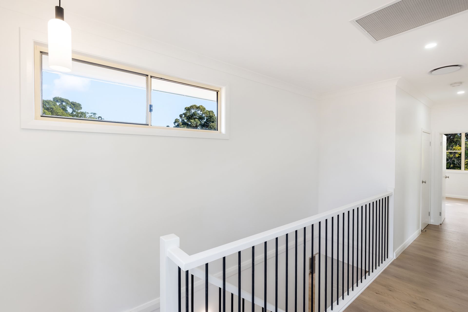 Bright White Hallway With Wood Floor and Small High Window — Matt Made Building in Camden, NSW