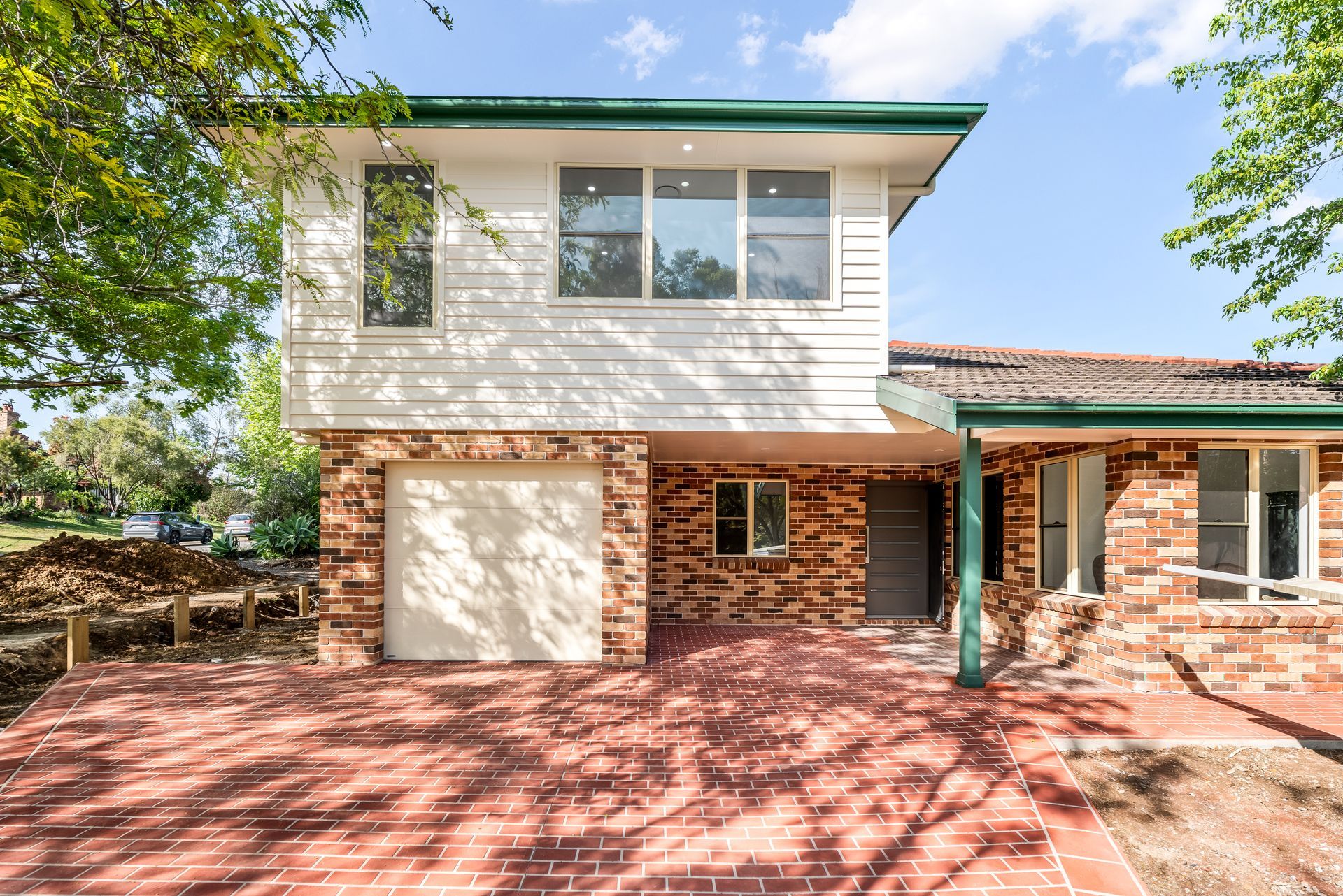 Two-story House With Brick and White Siding and Red Brick Driveway Under a Blue Sky — Matt Made Building in Camden, NSW
