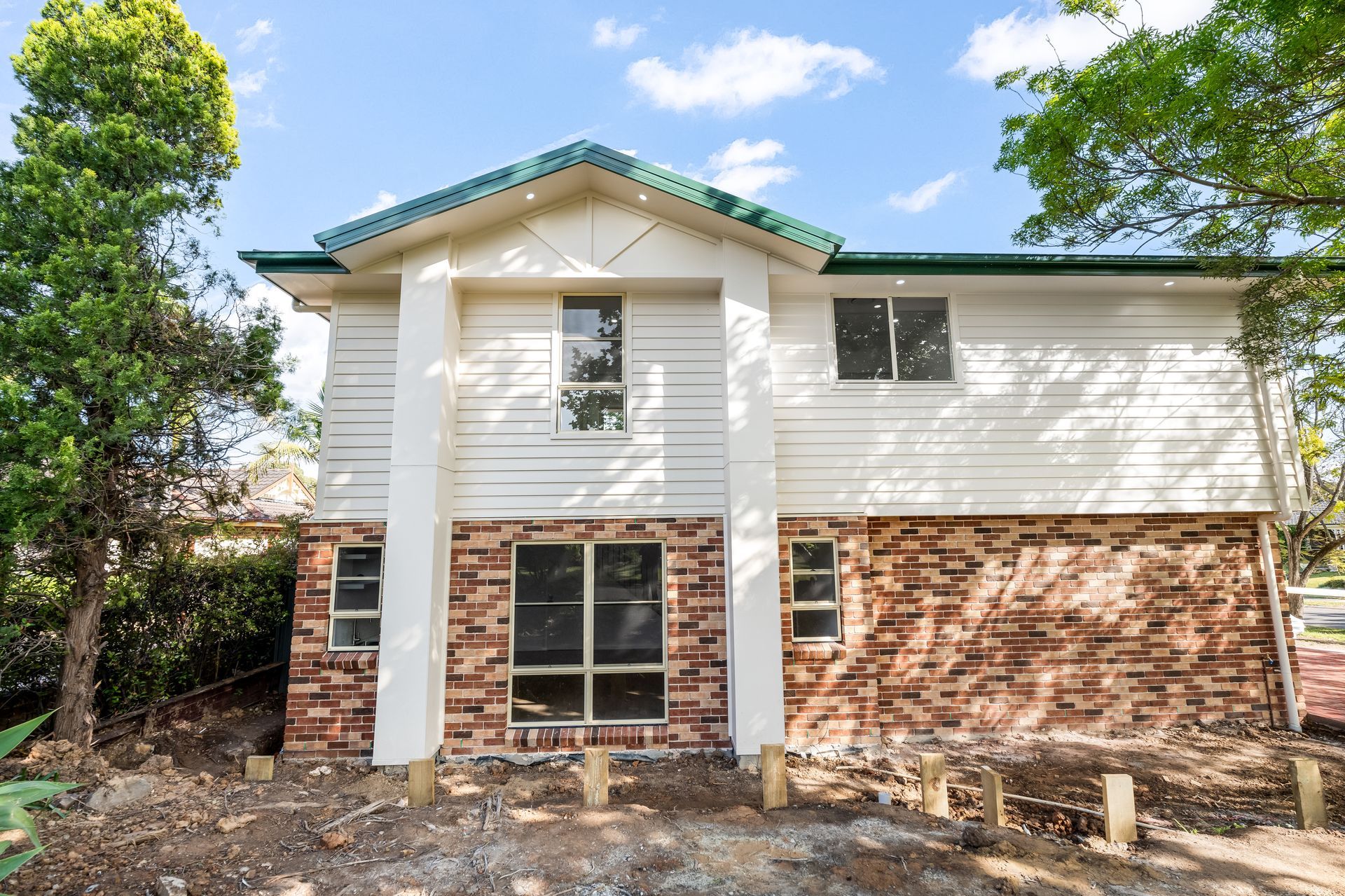 New Two-story House With White Siding and Green Roof Amid Trees — Matt Made Building in Camden, NSW