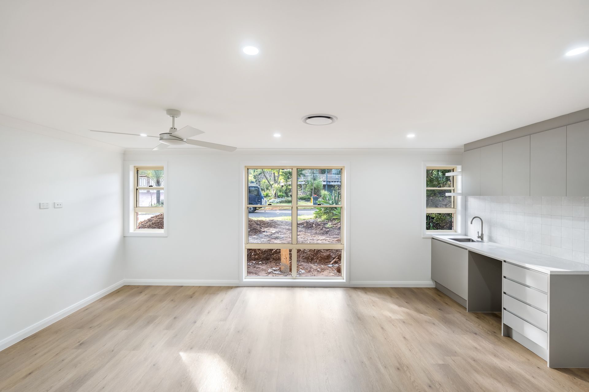 Empty Modern Kitchen With White Walls and Large Windows — Matt Made Building in Camden, NSW