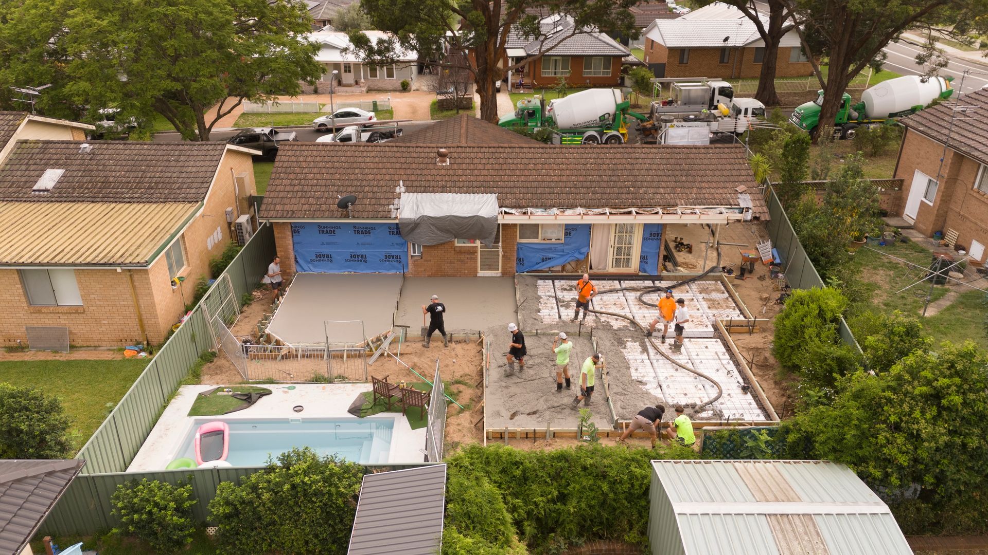 Aerial View of a Backyard With a Pool, Patio, and Several People Working Near a House — Matt Made Building in Camden, NSW